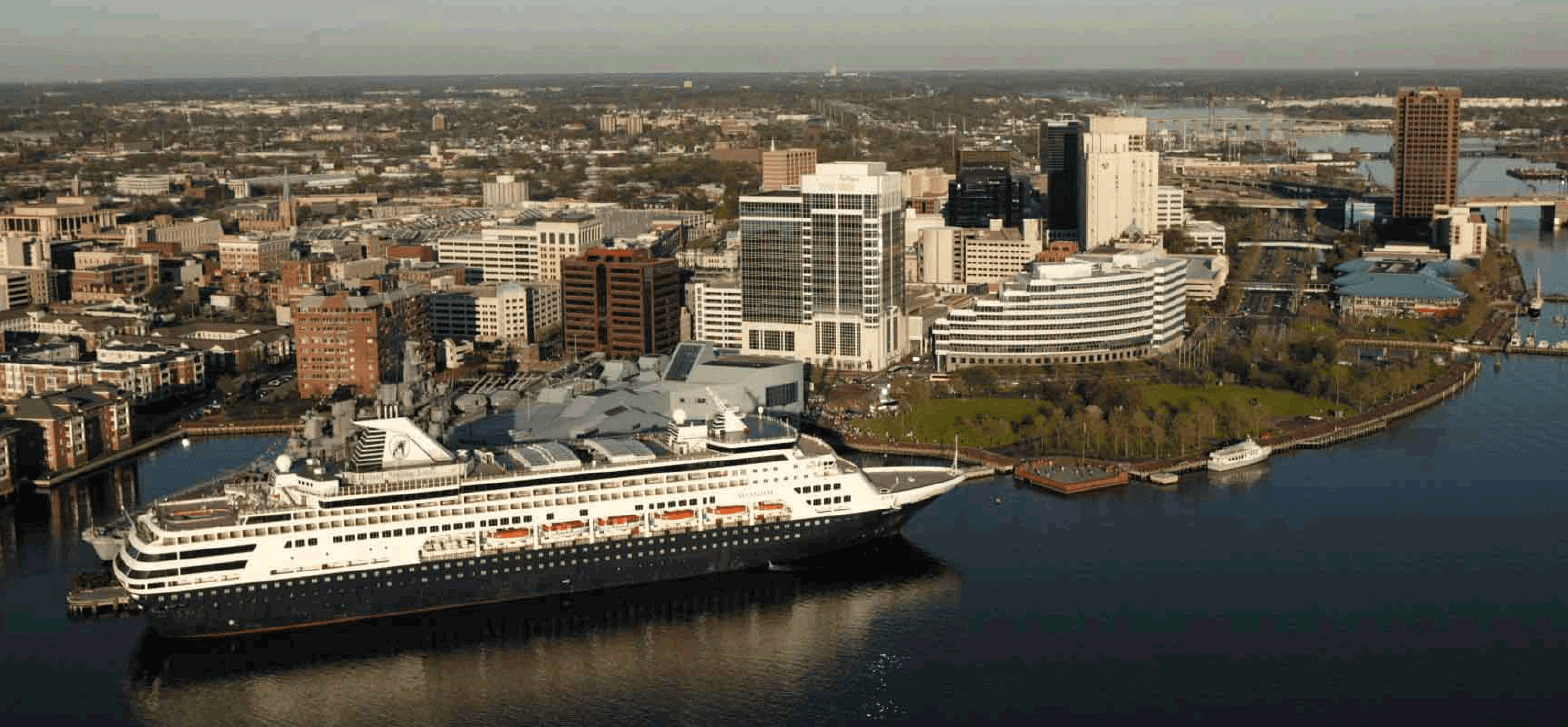 A cruise ship rests in the harbor at the National Maritime Center.