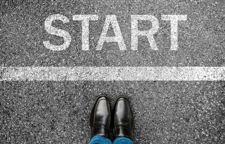 Business man standing on grunge concrete with white race line beginning idea. Top view. Feet and black shoes with word start written for concept on tarmac road background.