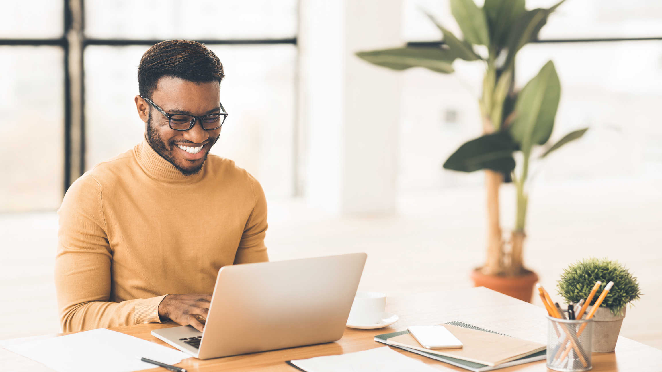 Headshot of handsome black guy using laptop