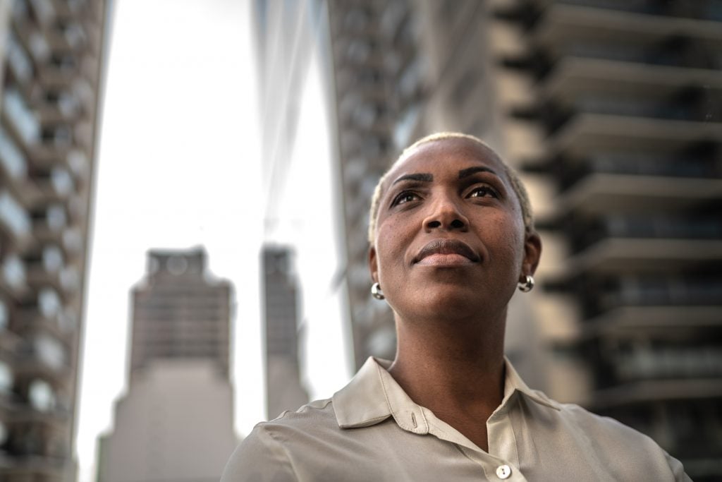 Businesswoman standing among glass skyscrapers