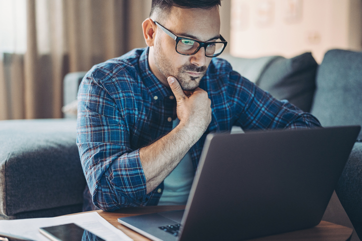 Worried man in front of a laptop at home